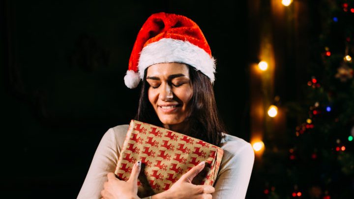 christmas, x-mas, winter, happiness concept - smiling woman in santa helper hat with many gift boxes