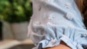 Woman holding open gordita filled with chorizo, beans, and cheese