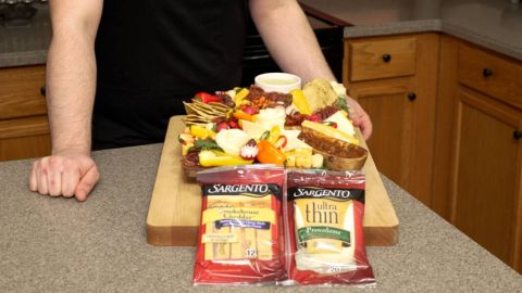 Brightly colored charcuterie board with sargento cheese packets
